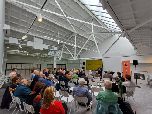 Mensen in een zaal in theateropstelling.