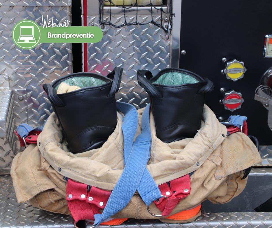 Twee brandweerlaarzen in eeen brandweer pak die staan op traanplaat van een brandweerauto. Daarop de tekst Webinar brandpreventie. 